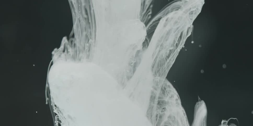 White fibers float near a black background