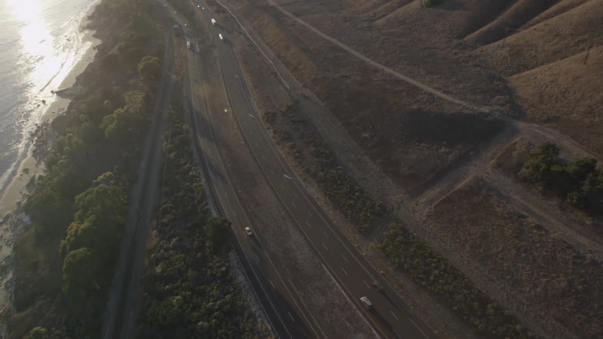 Aerial view of a coastal road with vehicles traveling