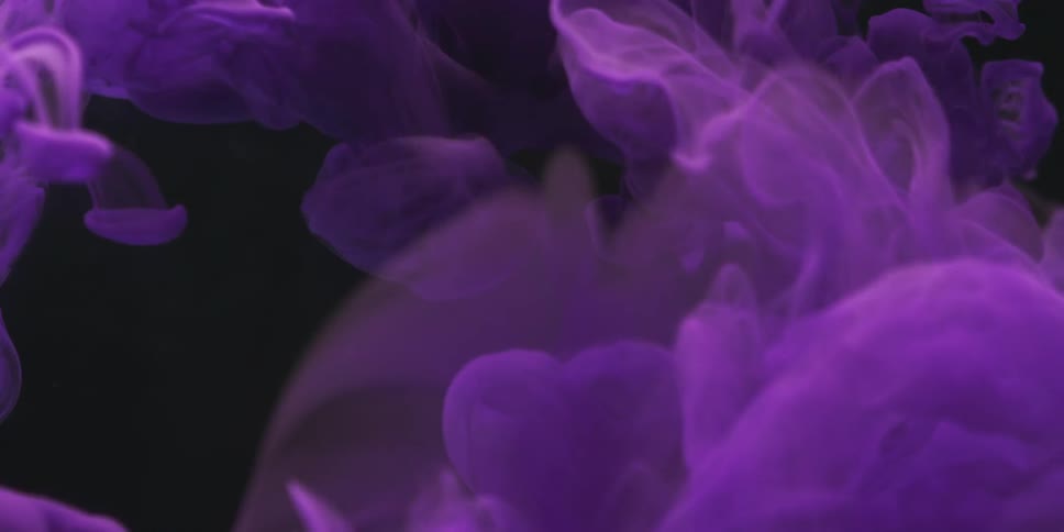 Purple lacy substance floats in a dark area