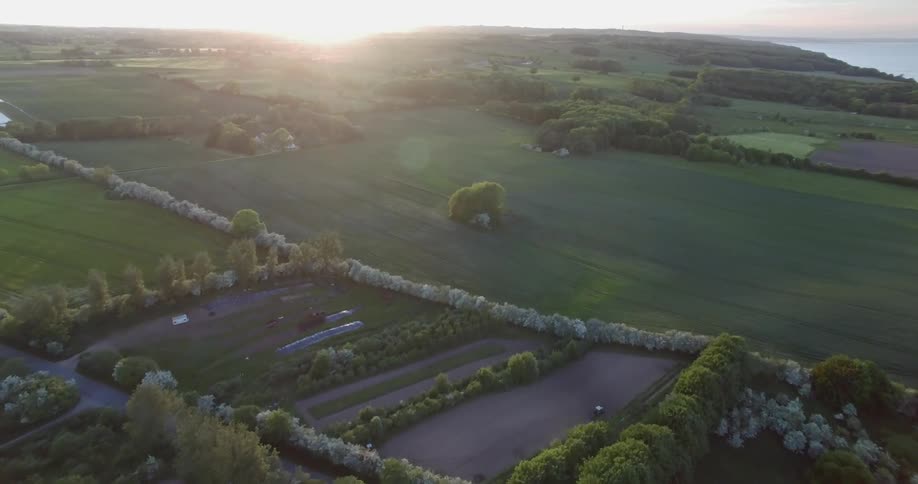 Sun setting on some farm lands and water