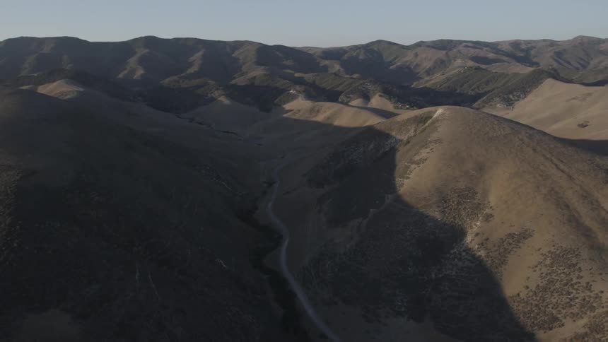 Aerial view of a road winding through mountain peaks