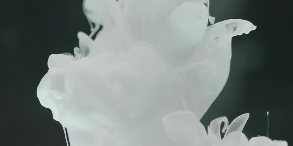 White plumes pour into a volume of clear liquid