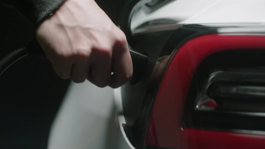 An electrical cord is plugged into an electric car