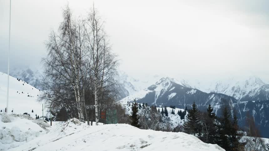 Clouds are hanging over a mountain valley landscape in winter