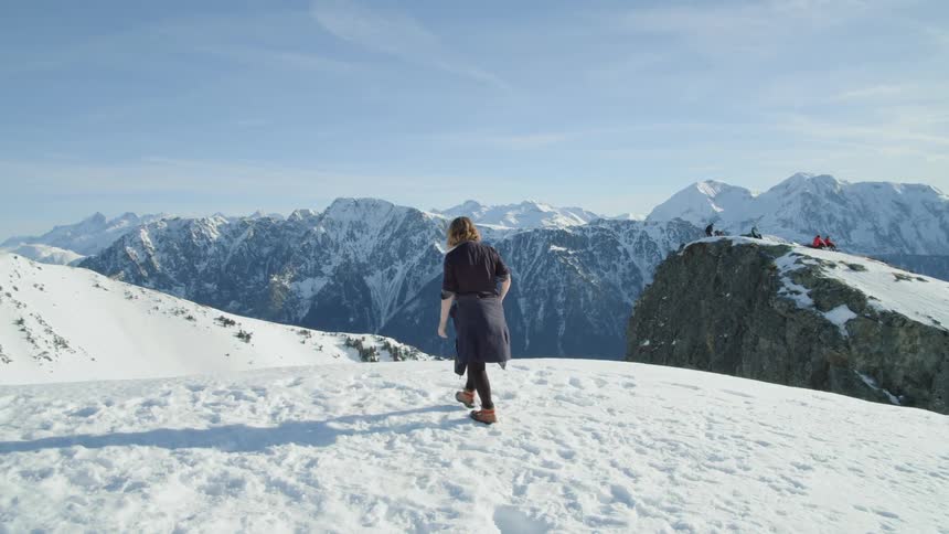 A woman hikes in snowy mountains