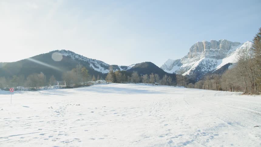 Snow-covered grounds with mountains in the distance