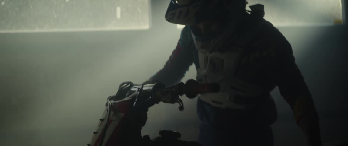 Person sitting on a motorbike in a garage turns the handlebars