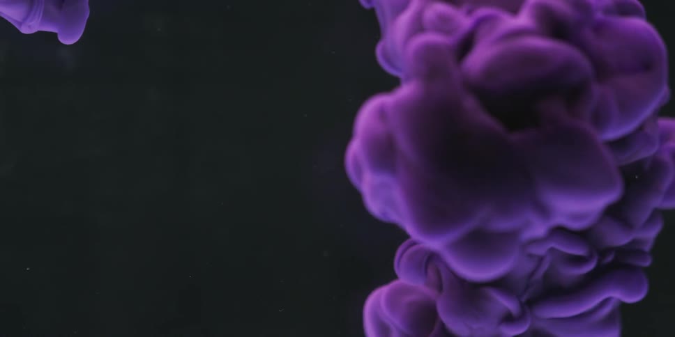 Purple smoke billowing in front of a black background