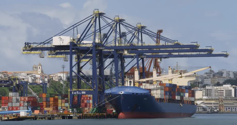 A barge sits docked with storage containers stacked on it