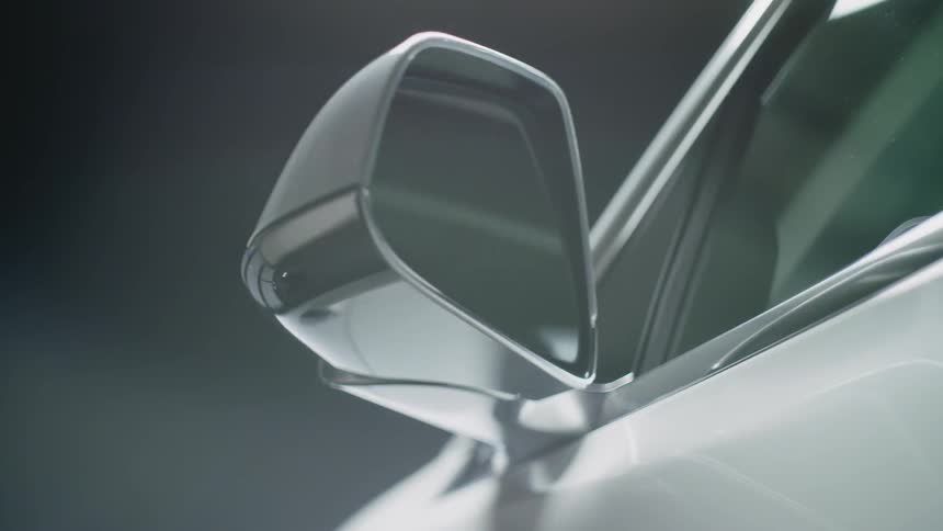 The sideview mirror on a car is flashing a light and folding toward the car