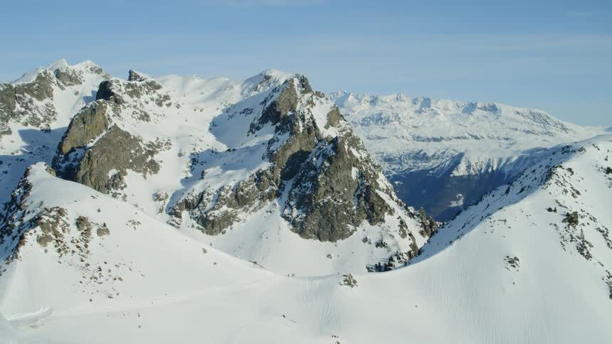 Snow covers mountains on a clear day