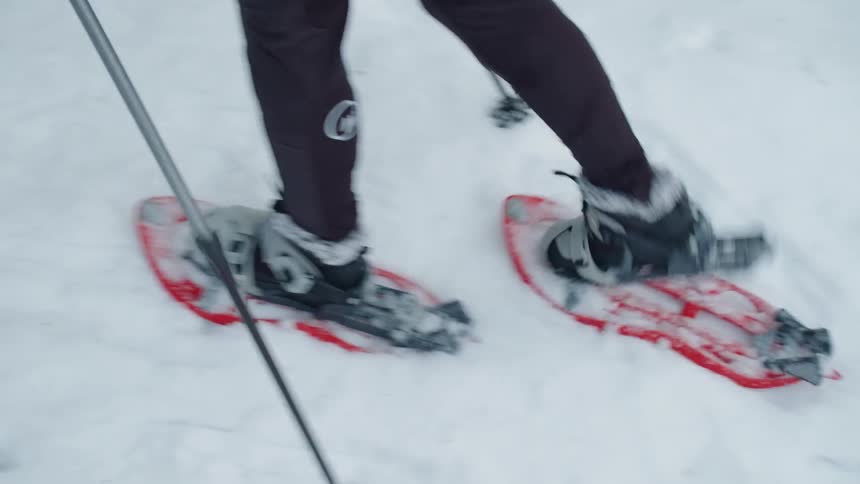 A person snowshoes over the snowy ground