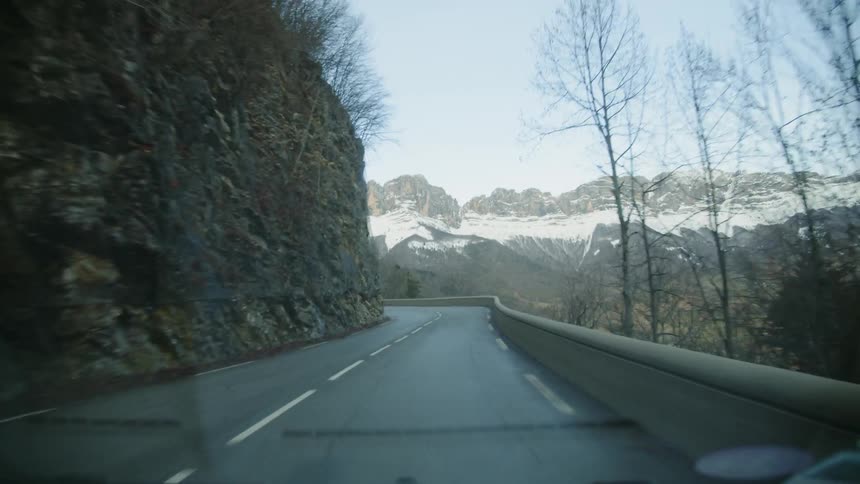 Vehicle travels over a winding road near the mountains