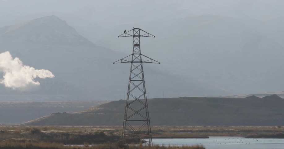 Tall tower sits next to a lake under a cloudy sky