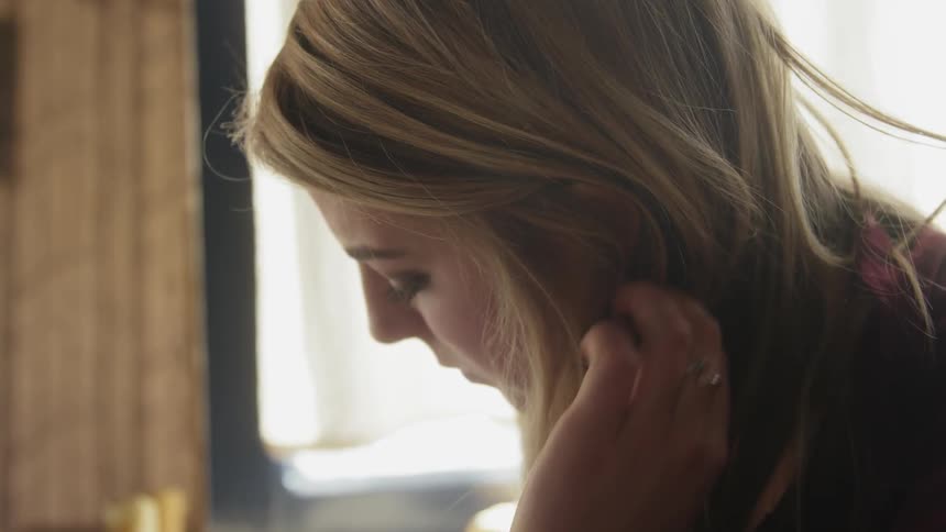 A woman tucks hair behind her ear