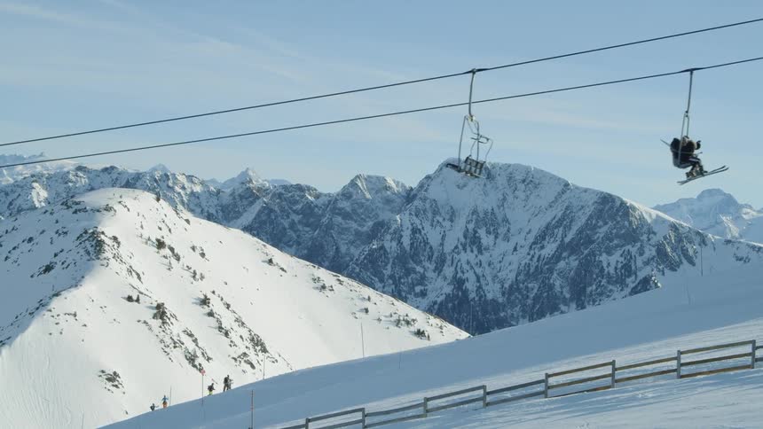 Ski lift cars travel back and forth up the mountain