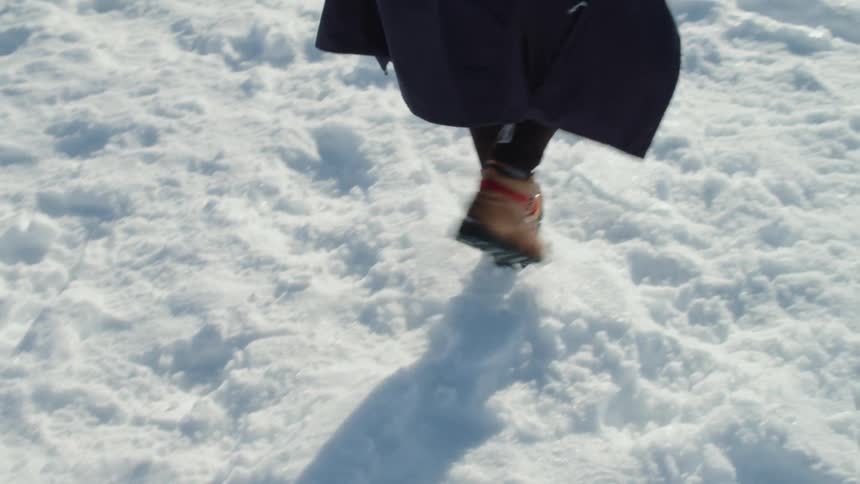 Woman walks over the snow in her boots