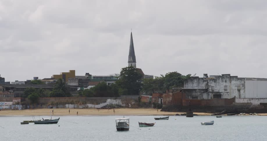 Boats float atop on the water by the city beach