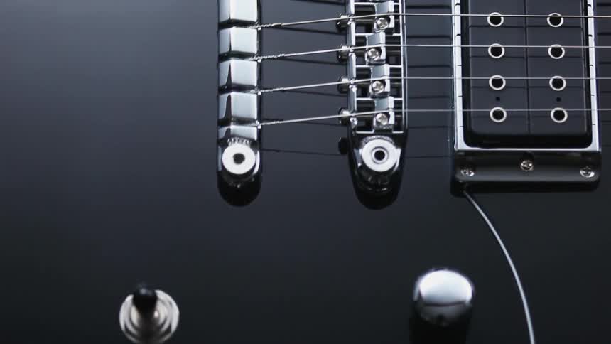 A black guitar with switches and strings attached