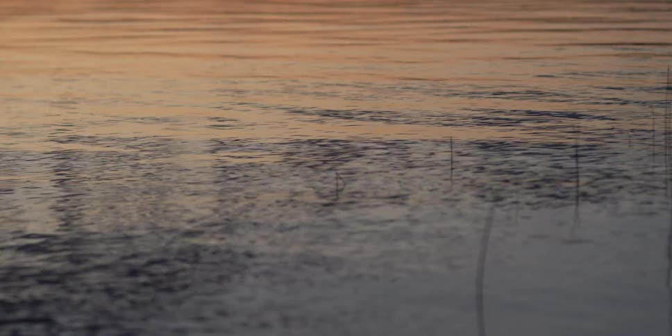 Water in lake is flowing and rippling at sunset