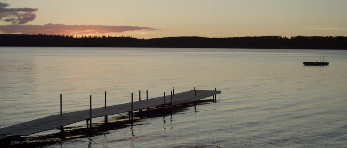 Lake water flows beneath a dock at sunset