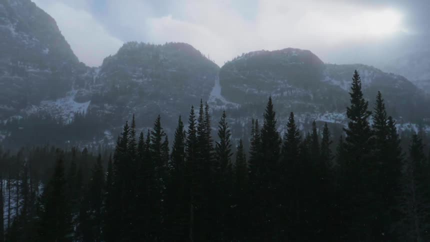 The mountains are covered with snow on a foggy day