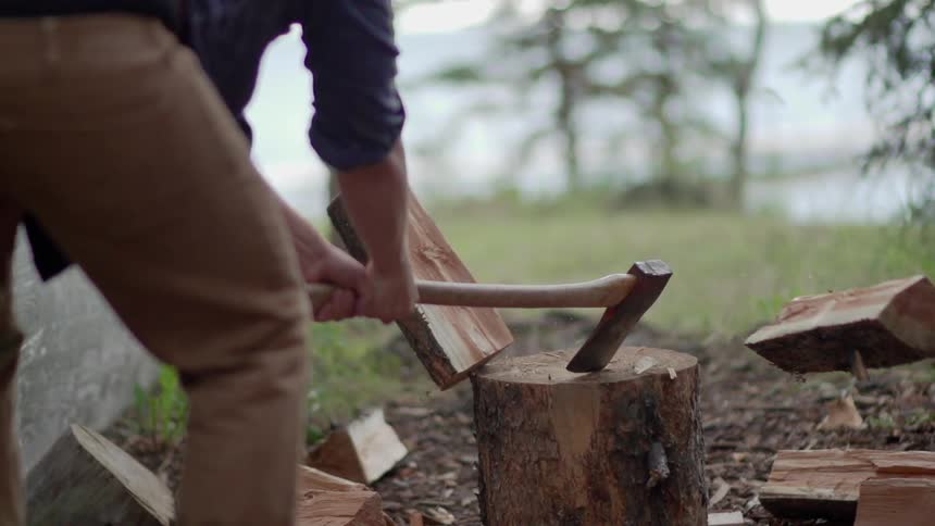 A man splits a log with an ax