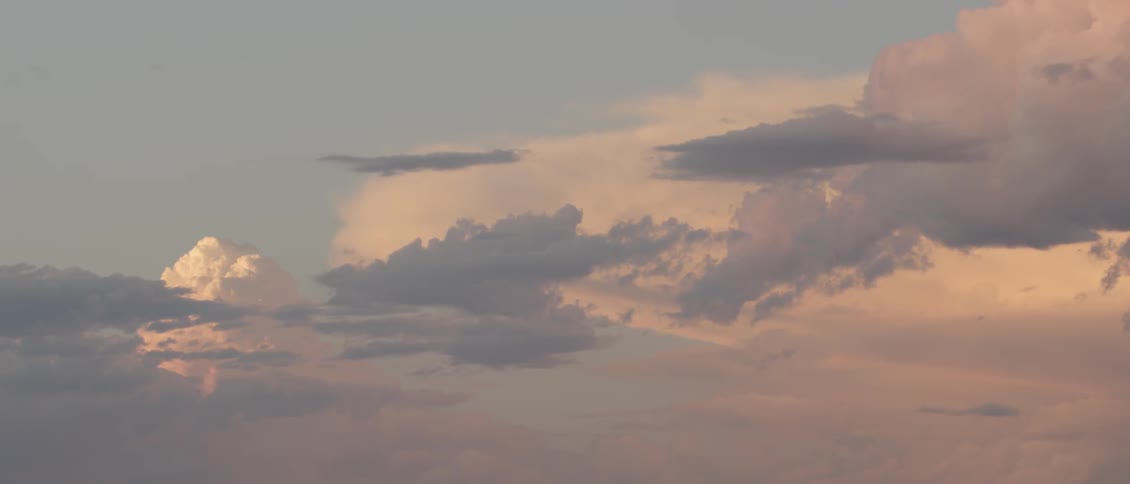 Gray and white clouds hang in the blue sky