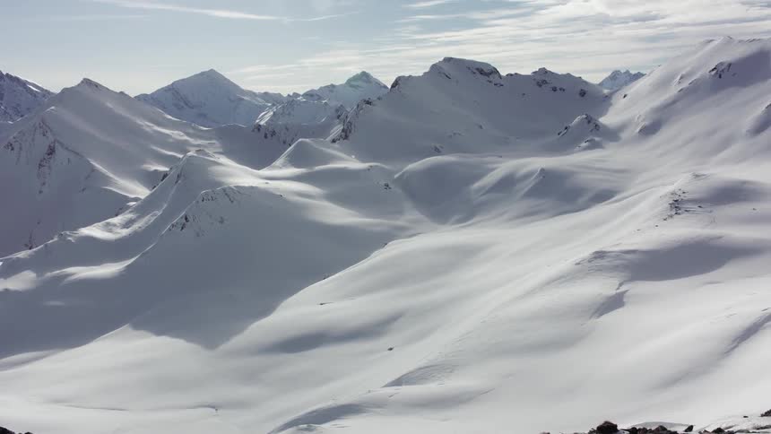 Snow covers peaks and ridges on a sunny day