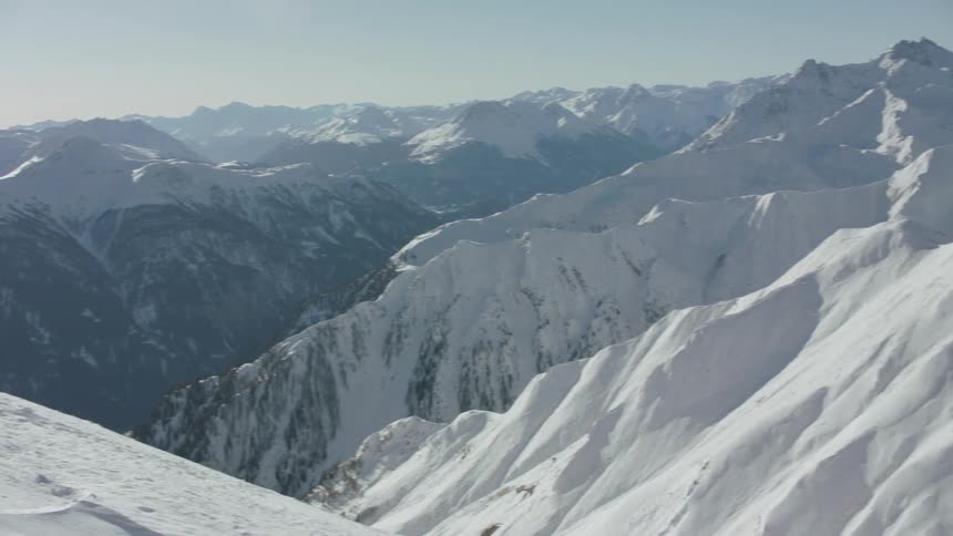 Snow covered mountain peaks and slopes on a sunny day
