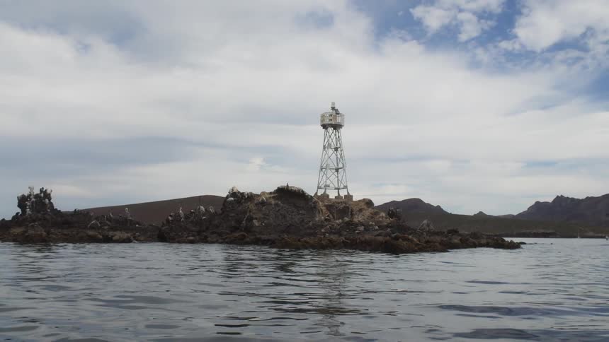 Across the water a tower is built by the shore