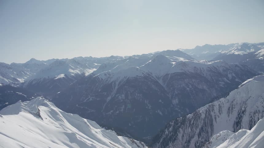 Snow covers mountains on a sunny day