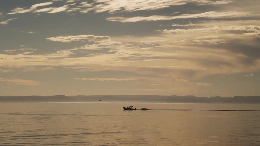 Small boat on a large body of water on a cloudy day