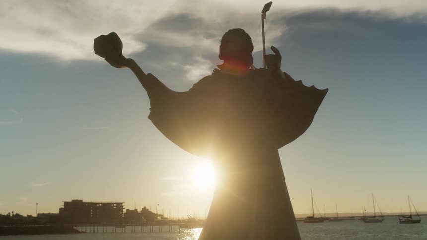 Statue of a person overlooking a large body of water