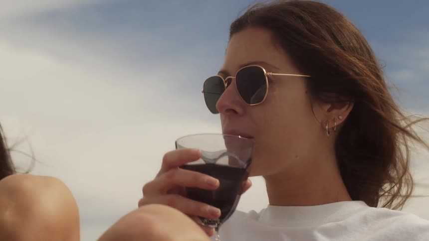 A woman sips wine from a glass