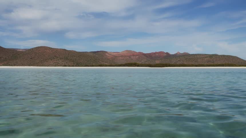 Traveling on the ocean past the hills on shore
