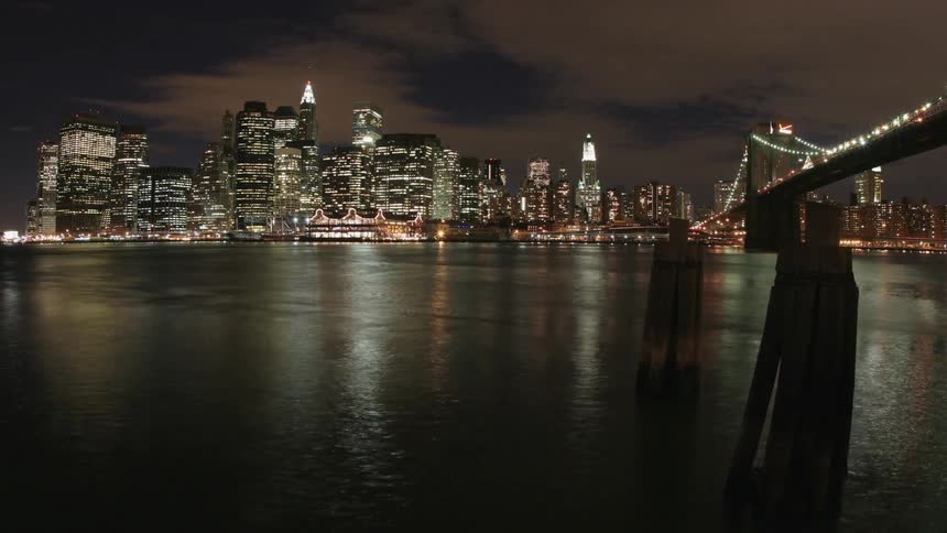 Timelapse of a nighttime skyline as a boat moves across the water