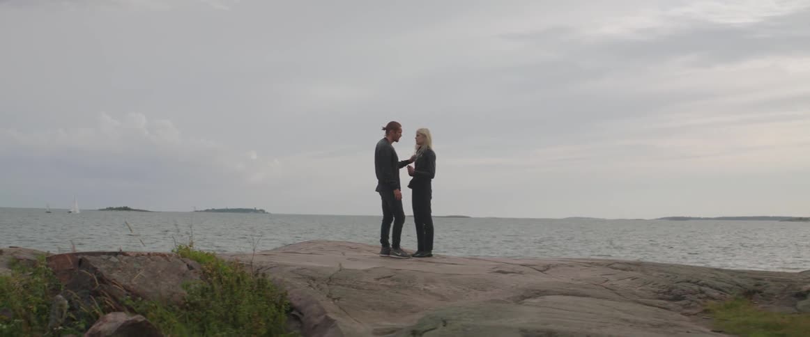 A boyfriend and girlfriend discuss their relationship problems while standing near the ocean