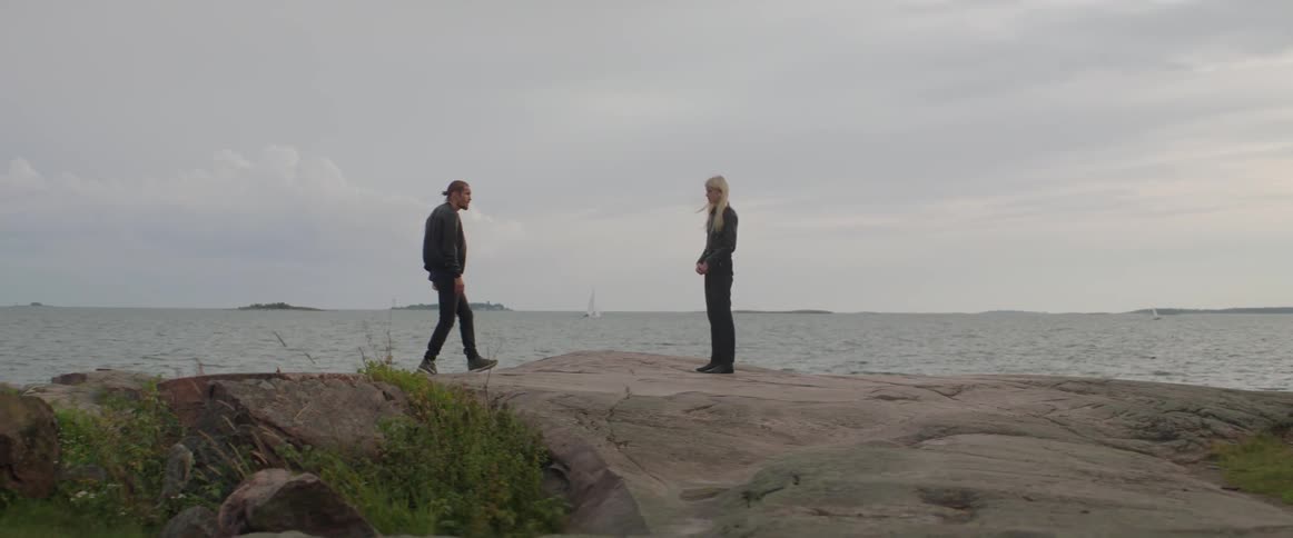 An angry boyfriend points his finger aggressively during a tense outdoor relationship argument.