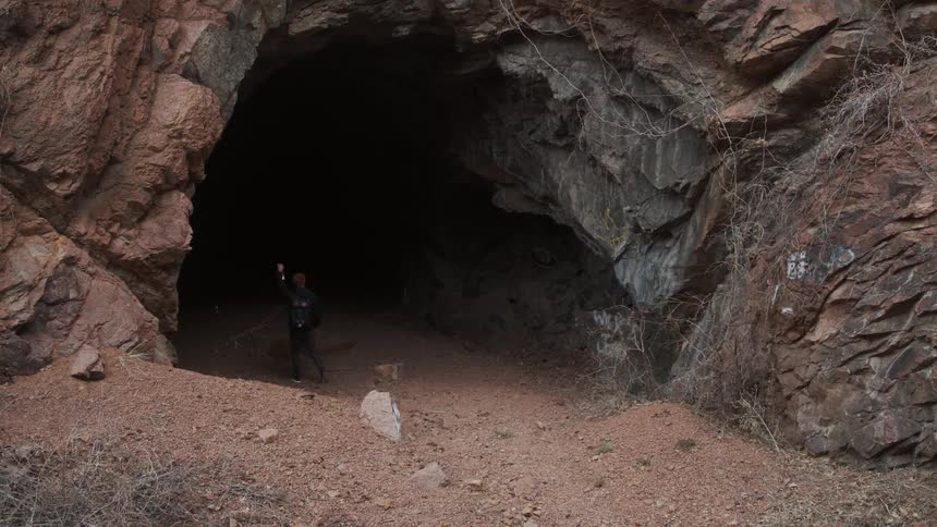 A man hikes into a cave