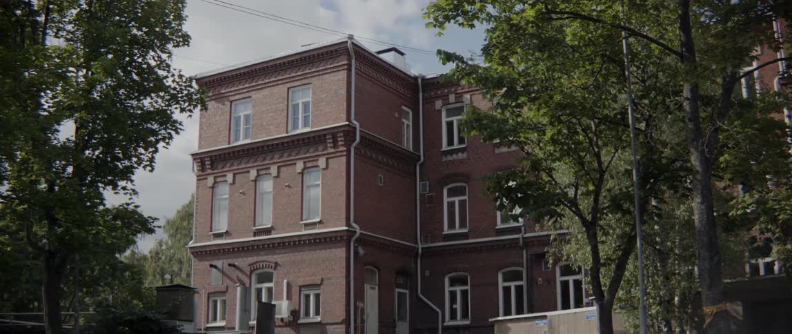 Old masonry architecture features multiple white windows on a quiet metropolitan street corridor.