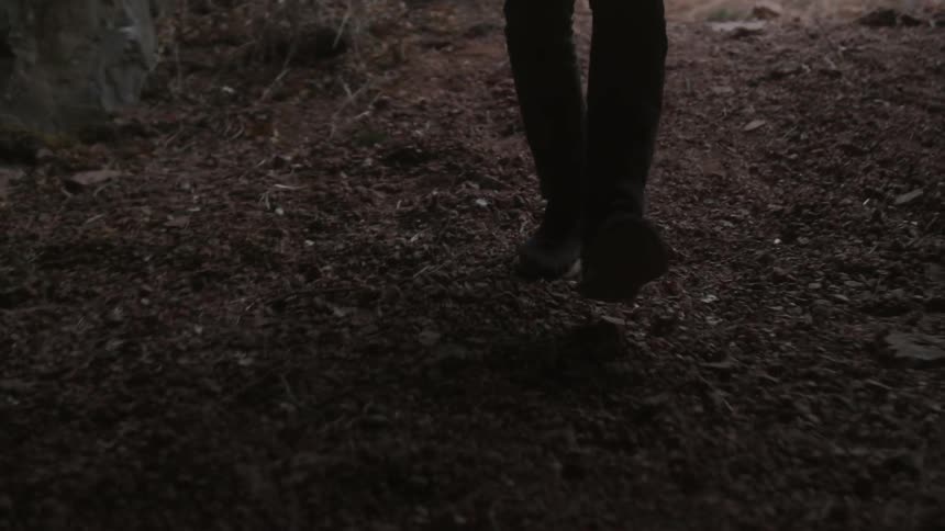 Man carrying lantern is walking into a dark cave