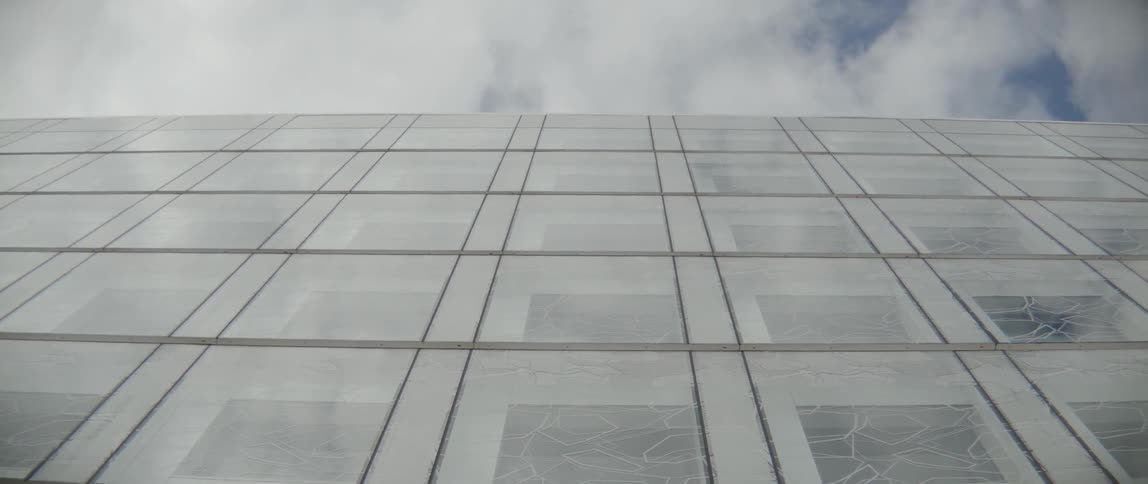 A minimalist view of a large corporate facility with geometric glass panel design.