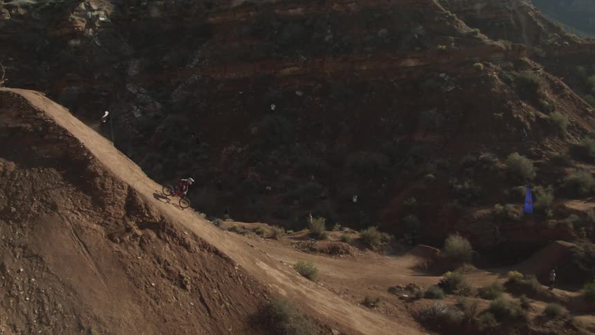A man is jumping off a cliff on a bike