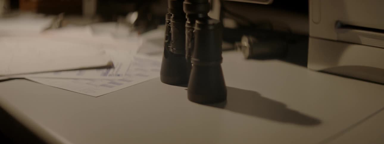 Papers and binoculars on a table top
