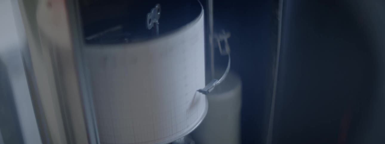 A needle slides along a white rounded sheet