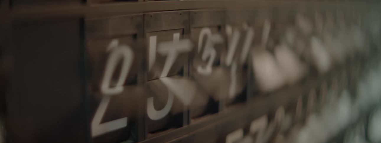 A blackboard has letters and numbers that are spinning around
