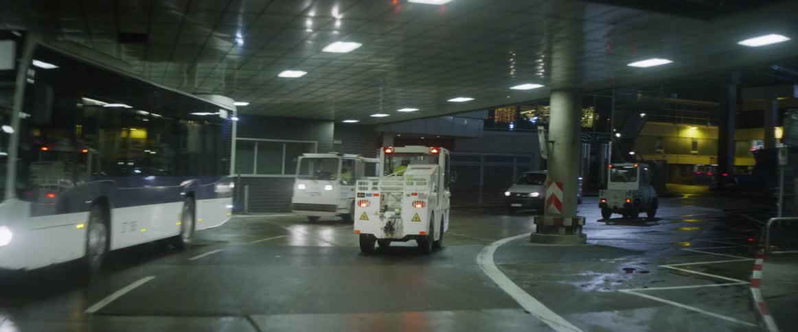 Buses and trucks travel on an airport road