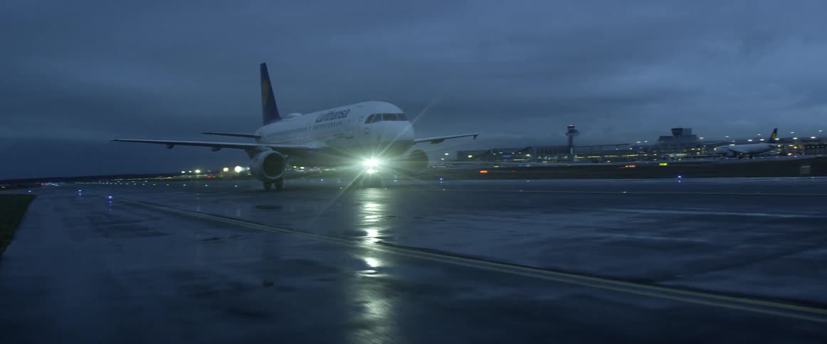 The plane is parked on the runway on a cloudy day