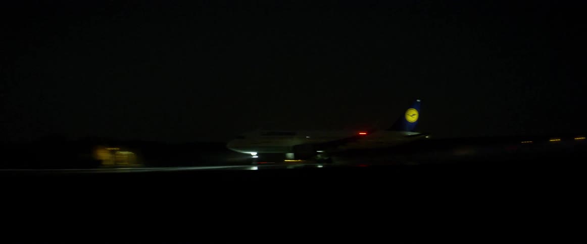 Large airplane lifting off runway at airport at night